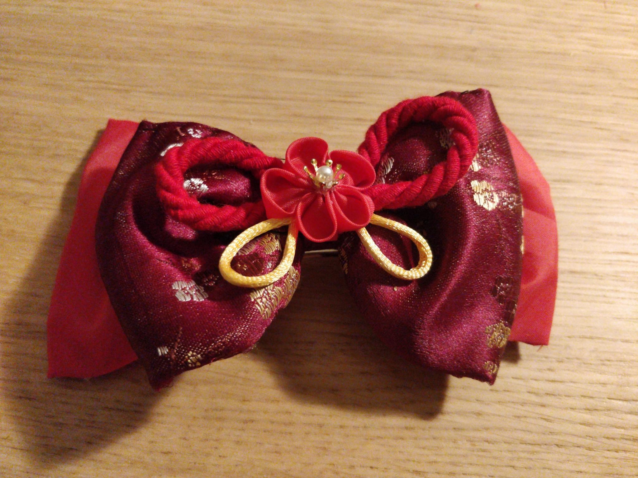 Gros nœud rouge avec une fleur au centre