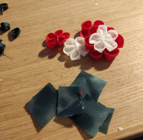 Photo prise en pleine réalisation, avec les pétales et fleurs non assemblés et les carrés de tissus